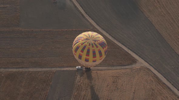 Colourful Hot Air Balloon with Envelope on Road Near Vehicle