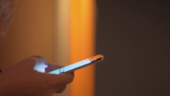 Woman typing sms when walking in hotel hall