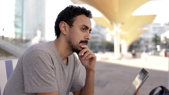 Pensive Man with Tablet Pc on Street