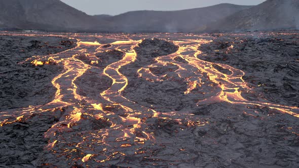 Flowing Lava Over Rocks In Smoking Landscape