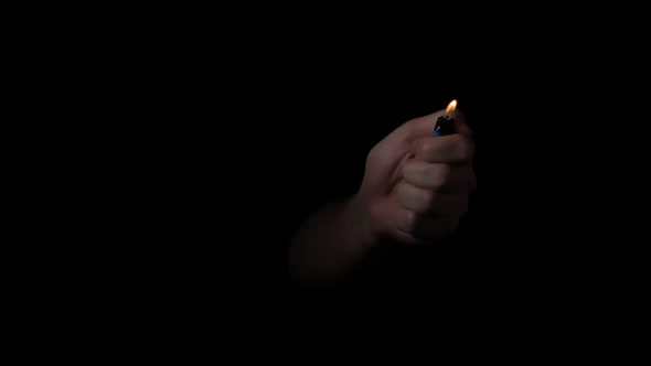 the Hand Appears From the Dark and Turns on the Lighter and Disappears.