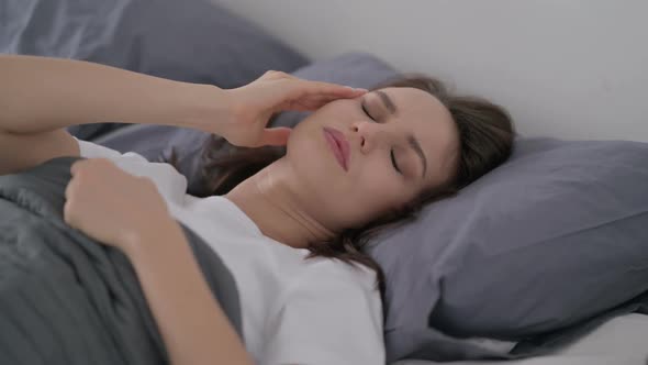 Woman Having Headache While Sleeping in Bed