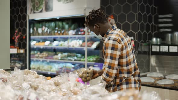 Man in Mask Push Cart Choosing Vegetables in the Fresh Produce Section