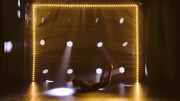 A Flexible Professional Female Athlete Performs Complex Acrobatic Elements of Rhythmic Gymnastics