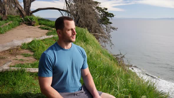 A man sitting in a meditation pose after a workout to practice mindfulness and stress relief on a be