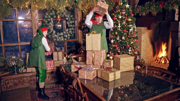 Happy elves with many presents indoors.