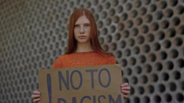 Girl Holding Cardboard with Phrase No to Racism Outdoors