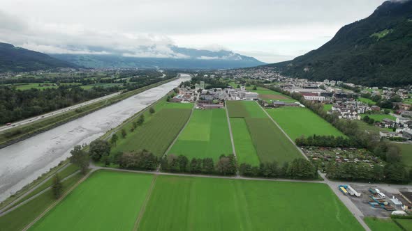 Liechtenstein with Houses on Green Fields in Alps Mountain Valley Aerial View