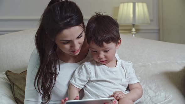 Mother Teaching Kid How to Use Tablet