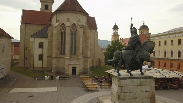 Aerial Upwards Pan of Statue of Mihai Viteazul in Alba Iulia with the back of the church and trees