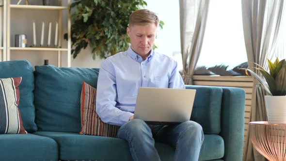 Casual Middle Aged Man Working with Laptop in His Lap