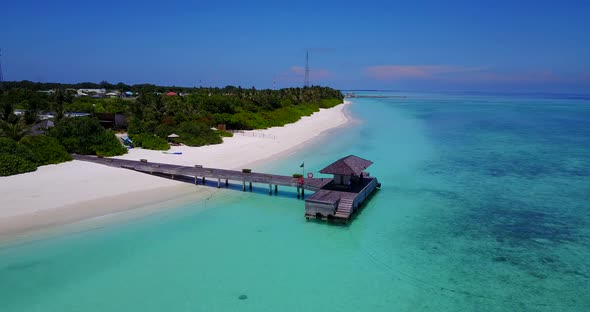 Tropical above tourism shot of a white sandy paradise beach and blue sea background in 4K