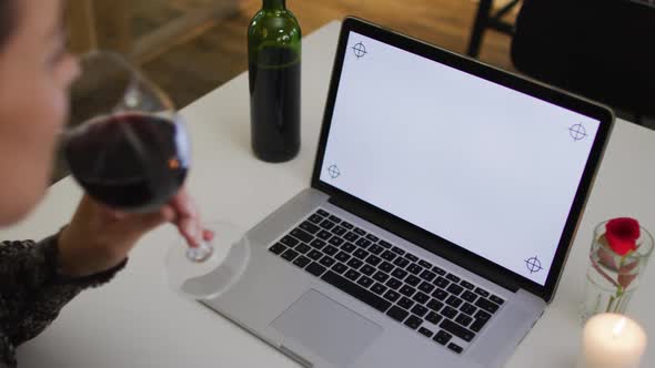 Caucasian woman having a romantic dinner on video chat using laptop with copy space