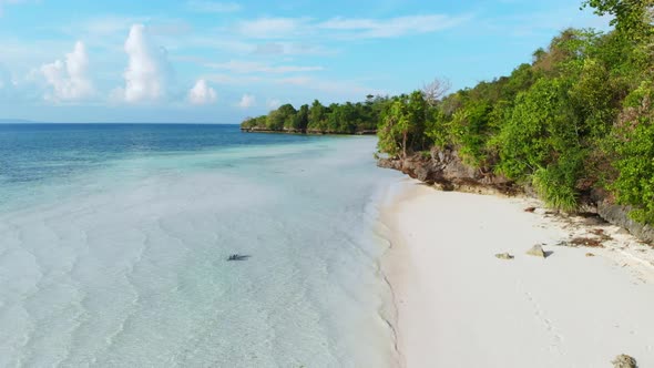 Aerial slow motion: woman walking on tropical island turquoise water white sand