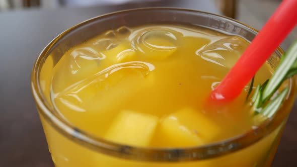 Cold orange drink in a thick glass Close up