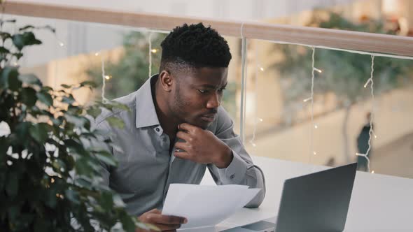 Young Male Manager Sitting at Workplace Checking Correctness Data on Laptop Serious Puzzled Pensive