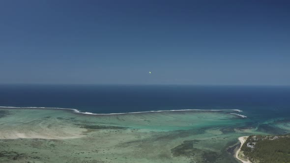 Aerial view of a person doing paragliding among the mountain, Mauritius.