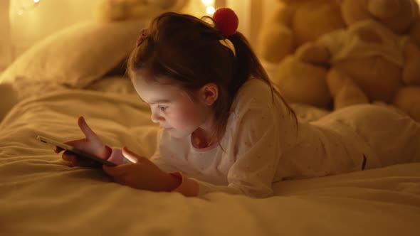 Cheerful Girl Browsing Tablet on Bed in Evening