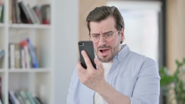 Portrait of Man in Glasses Loss on Smartphone