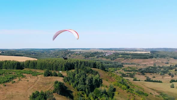 Paraglider Is Lowering and Flying Over the Forest