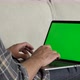 Close-up of a Man Uses Laptop with Green Mock-up Screen While Sitting on sofa in His Cozy Living - VideoHive Item for Sale