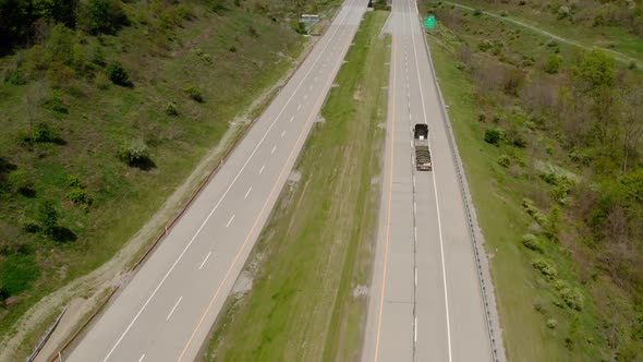 Aerial Drone Shot of Truck Rides on Road That Turns