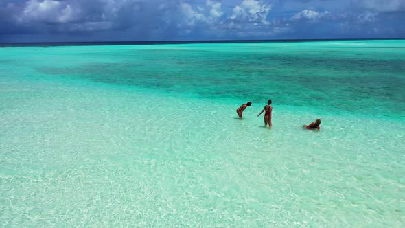 Tree attractive young bikini girls swimming in the endless crystal clear seawater. A sunny summer da