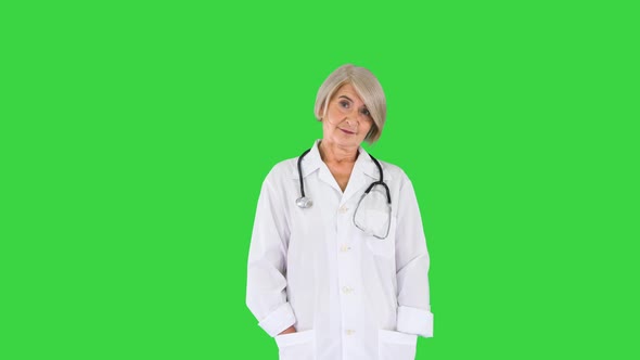 Senior Doctor Standing with Hands Folded and Looking To Camera on a Green Screen Chroma Key