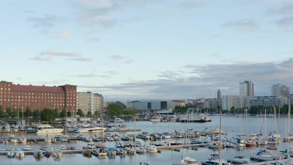 Slow aerial pan of small and large boats in a dock along the waterfront of Helsinki, Finland.