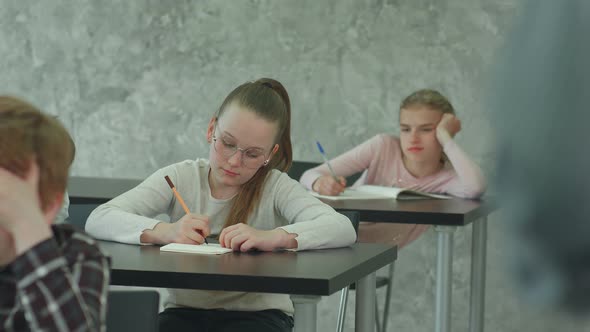 Students in School Uniform Taking Exam at Desk in a Classroom