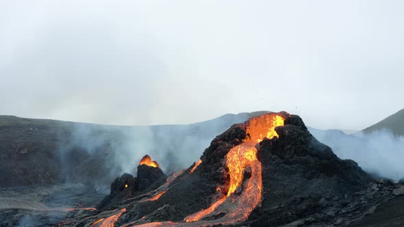 Close Up Of An Erupting Volcano Crater With Boiling Lava And Toxic Smoke. aerial tilt down