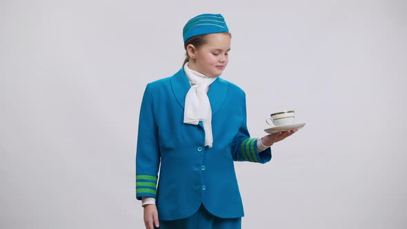 Positive Smiling Cute Girl in Stewardess Uniform Posing with Tea Coffee Cup at White Background