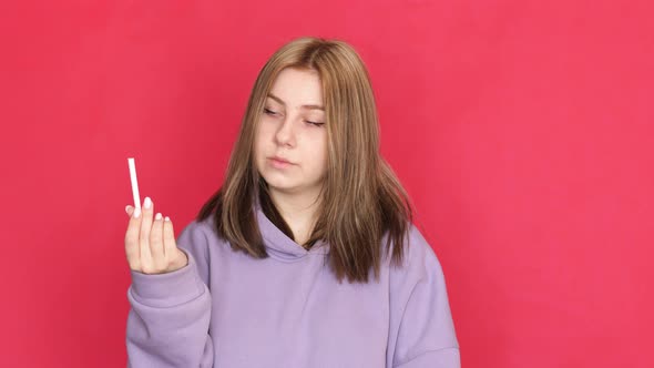 The harm of smoking for a woman concept. A young caucasian woman in her 20s holds a cigarette in her