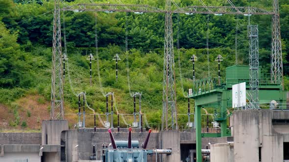 Power Lines Go Up the Mountain From the Hydroelectric Plant Transformer