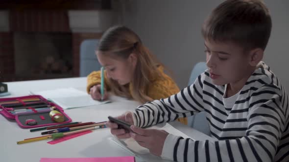 Two Caucasian Children Sitting at the Table at School