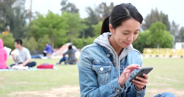 Young woman use of mobile phone at outdoor park