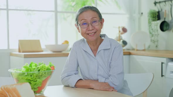 Portrait of elderly older grandmother wear eyeglasses, feel happy and enjoy retirement life in house