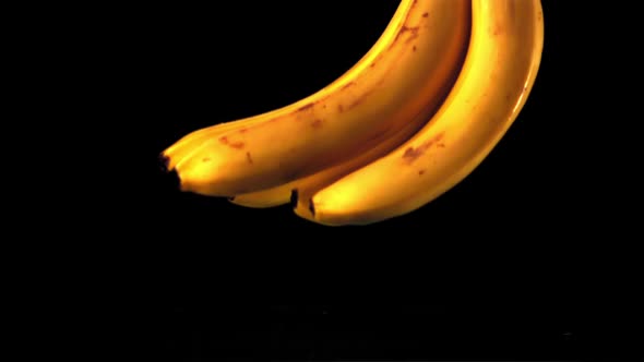 Super Slow Motion Ripe Bananas Fall Into the Water with Splashes