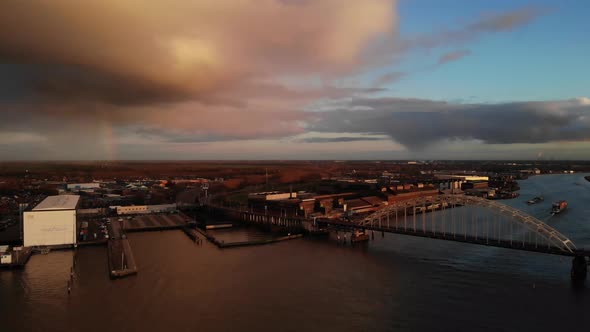 Dramatic Clouds In Sunset Over Arch Bridge Spanning Noord River In Alblasserdam, Netherlands. - aeri