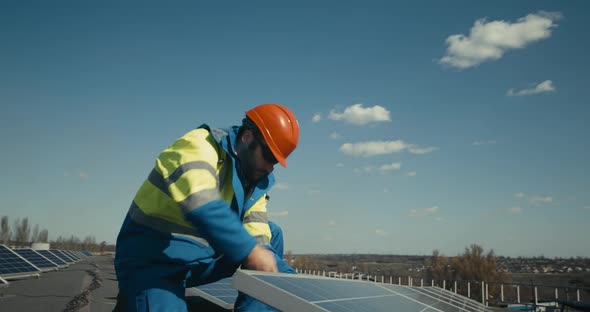 Technician Installing Solar Panel on Flat Roof