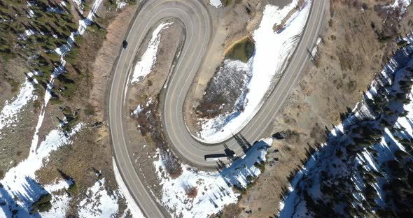 Overhead view of switchback road on Million Dollar Highway in Colorado with a car and semi-truck dro