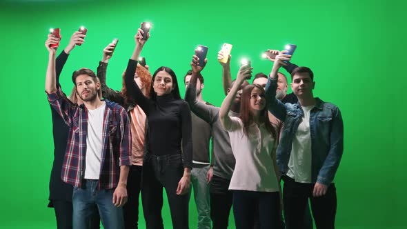 Crowd of People of Different Ages Dancing at a Concert People Holding Smartphones with Flash Lights