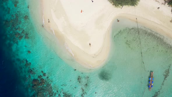 Young Woman Is Lying on the White Sand of a Tropical Island, Beach with Waves of Azure Sea. Camera