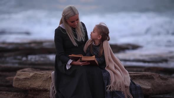 Woman Reading a Book By the Girl on the Coast in the Evening Slow Motion