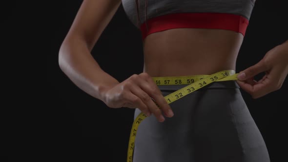 Woman measuring her waist