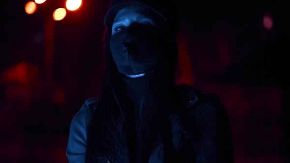 Girl in a Black Virus Mask Looks at the Camera in Blue Lights