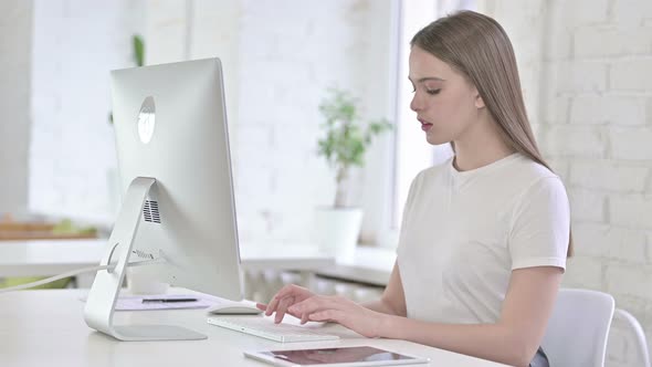 Ambitious Young Woman Working on Desktop in Office
