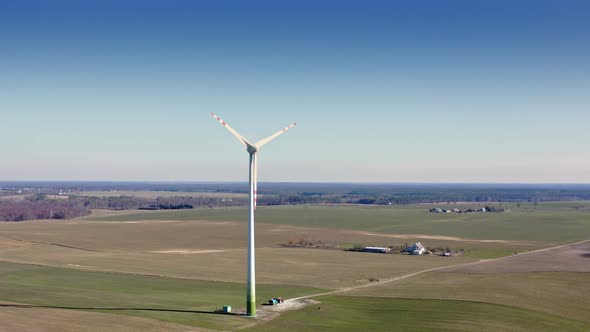 Wind turbine on field in sunny day, aerial view