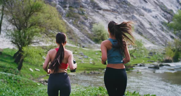 Two Young Women in a Sportswear at Nature Get