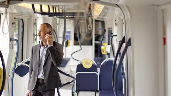 Businessman in commuter train talking on the phone
